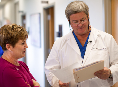 Dr. James Davison, Wolfe Eye Clinic LASIK surgeon, discusses LASIK candidacy evaluation results with nurse in Iowa.